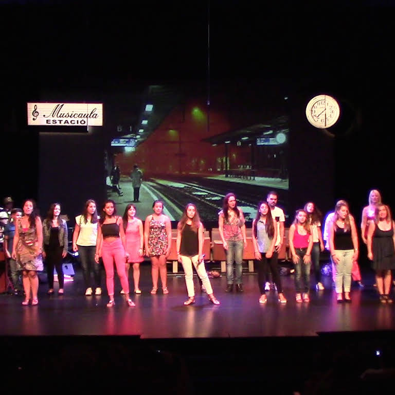 Foto del Musical 'Estació Musicaula', on surt una coral cantant a l'escenari del Teatre Sagarra.